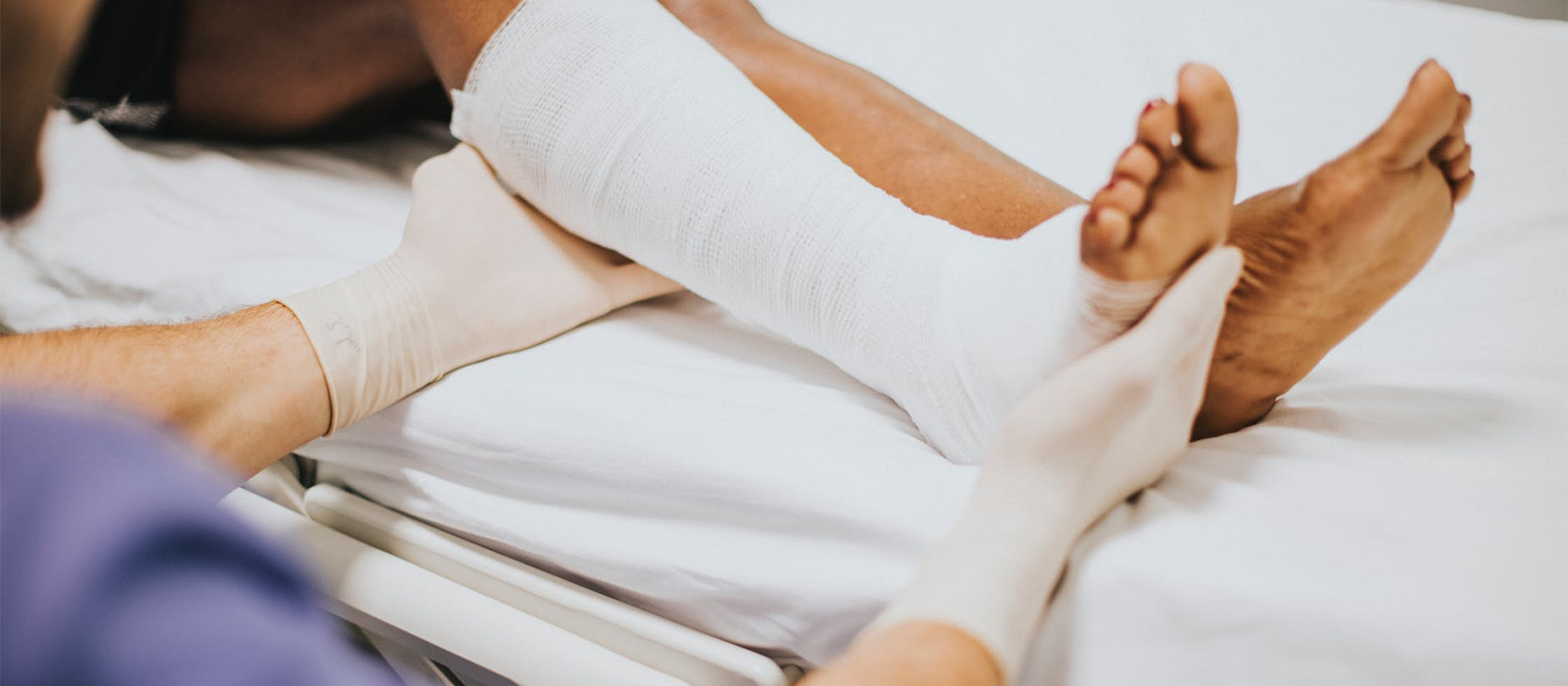 doctor supporting a bandaged lower leg and foot