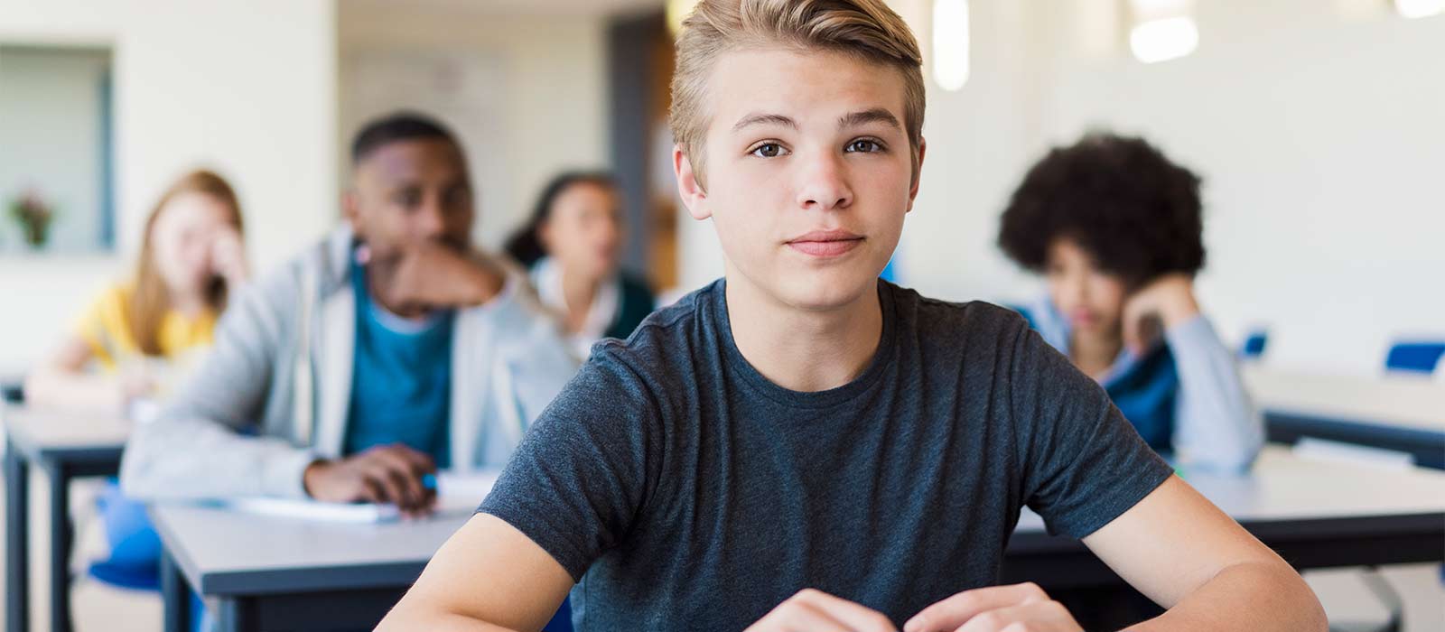 adolescent boy sitting in classroom