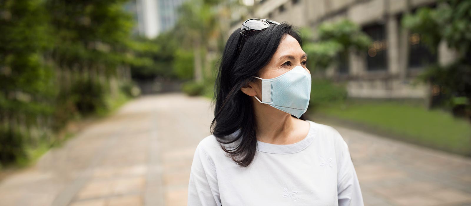 Middle aged Asian woman wearing protective mask.