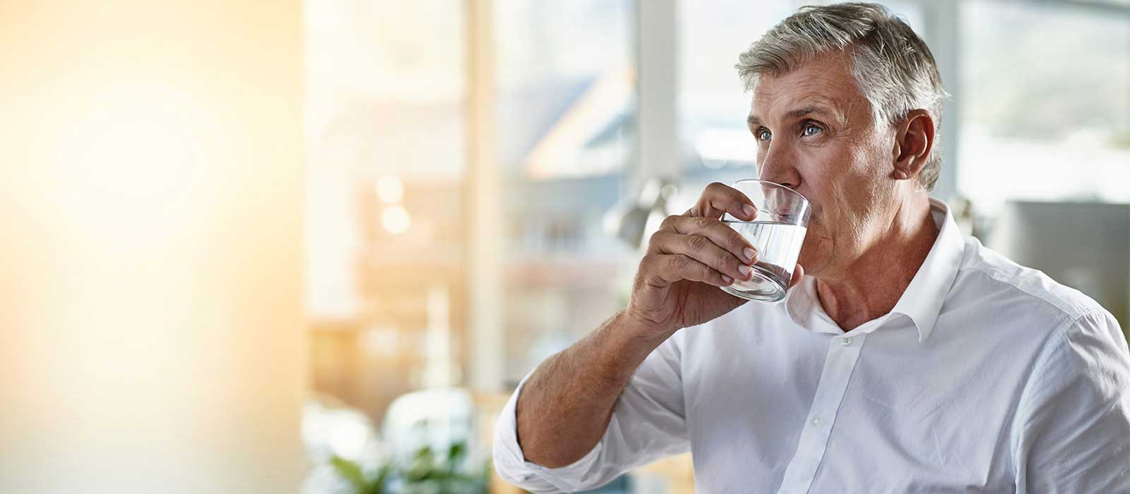 Mature man drinking water.