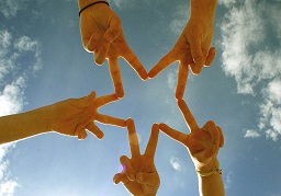 people joining hands to make a star shape