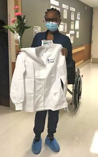 Fatima Bah, BSN, RN, CMSRN holds her new Certified Nurse jacket