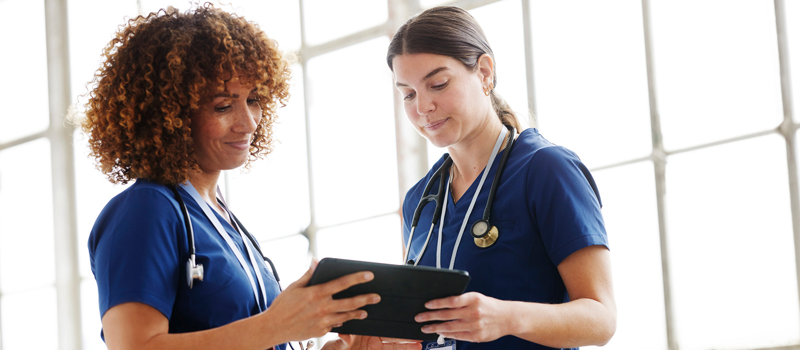 two nurses speaking indoors