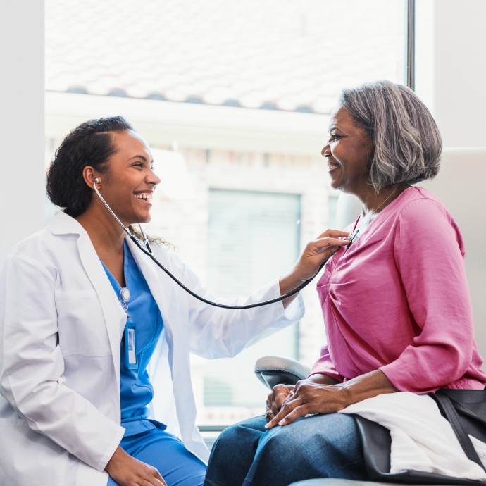 a doctor holding a stethoscope to a patient's chest